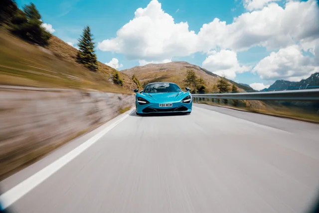 Türkisfarbener McLaren in Fahrt an einem See