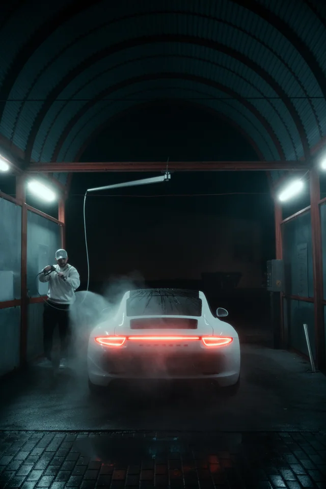 Aufbereiter mit Dampf hinter dem Porsche